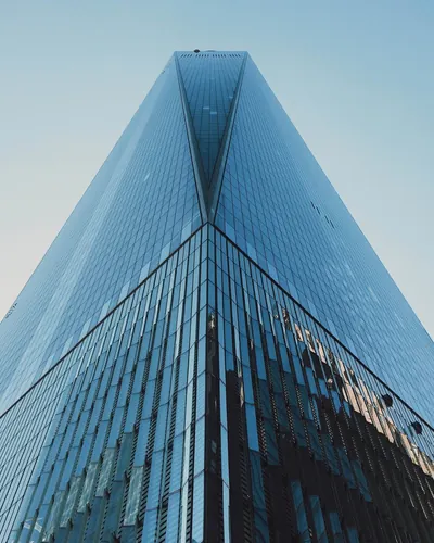 Reflective glass facade of a tower seen from street level